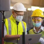 Two,Engineer,In,Hard,Hat,Wearing,Safety,Using,Laptop,For